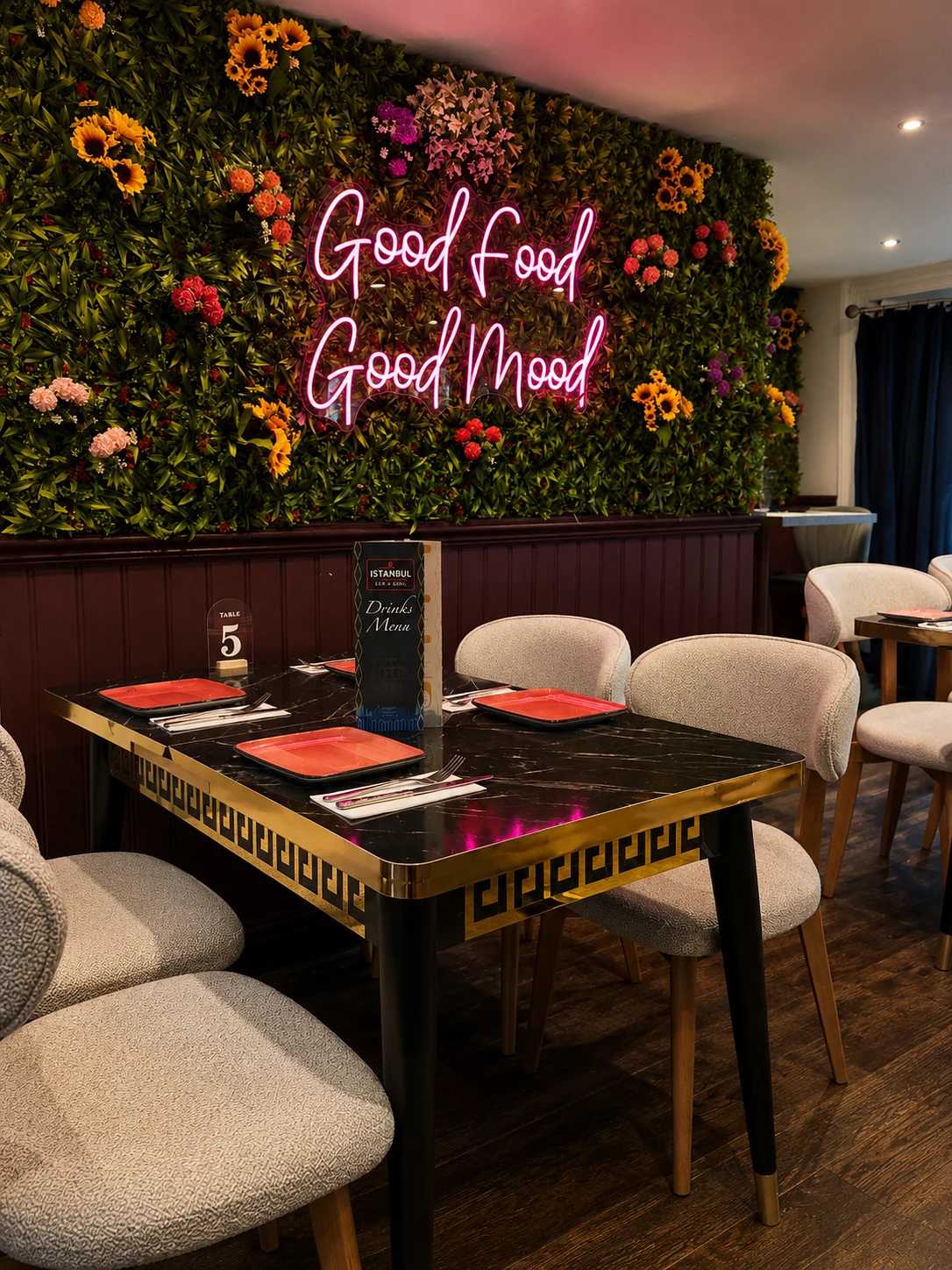 Dining table set against a colourful botanical wall